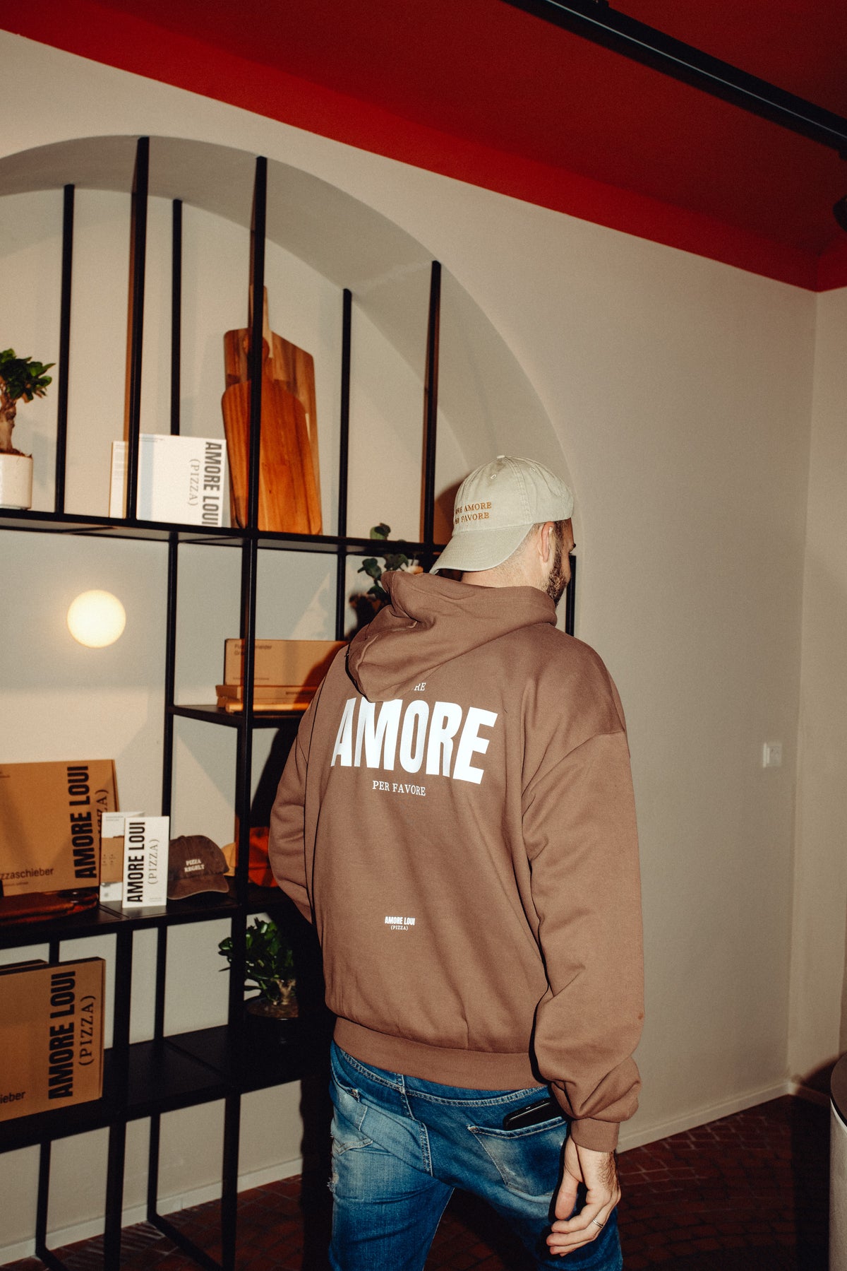 Mann trägt den braunen AMORE LOUI Oversized Hoodie, seitliche Ansicht
