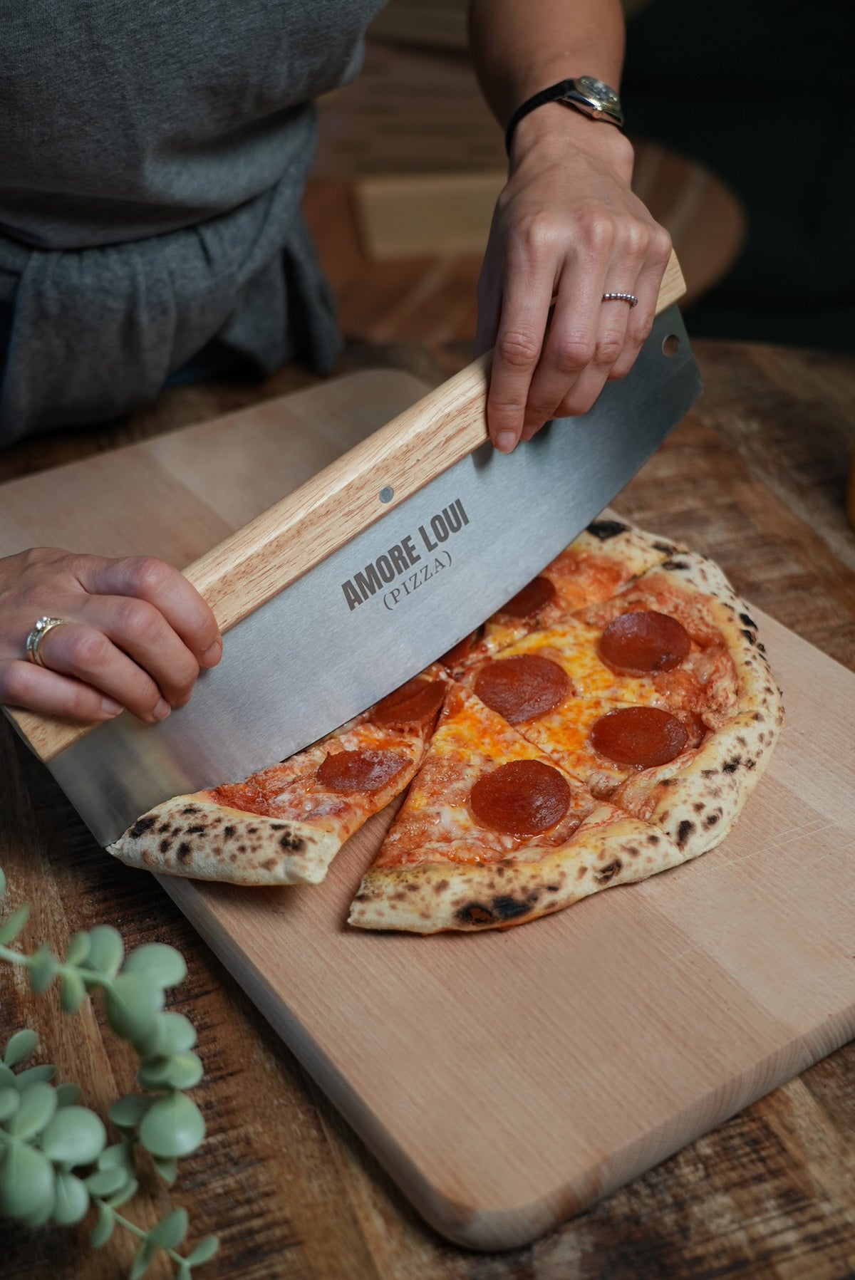 Pizzaschneider Grande beim Schneiden einer Pizza