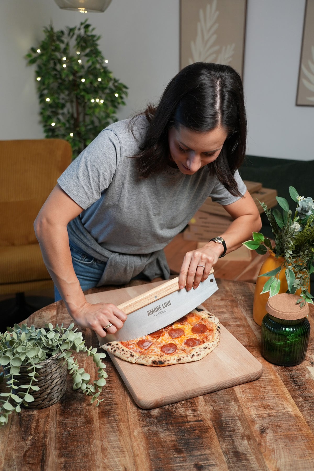 Frau schneidet eine Pizza mit dem Pizzaschneider Grande