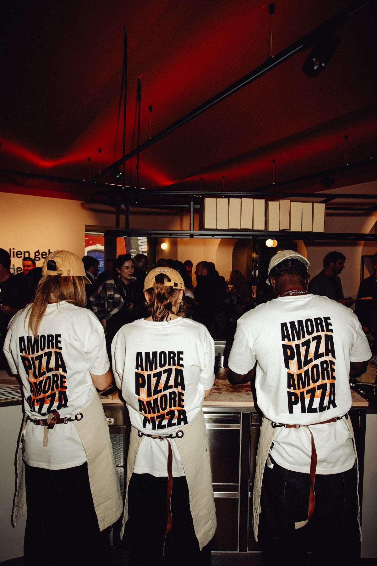 Personen mit weißen AMORE PIZZA Shirts in der Pizzeria