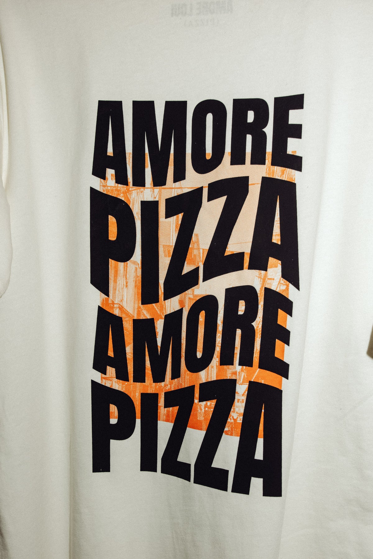 Nahaufnahme des weißen Shirts mit dem Druck „AMORE PIZZA“