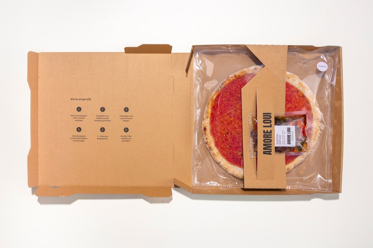 Geöffneter Karton mit glutenfreiem Pizzaboden und separat verpackten Zutaten