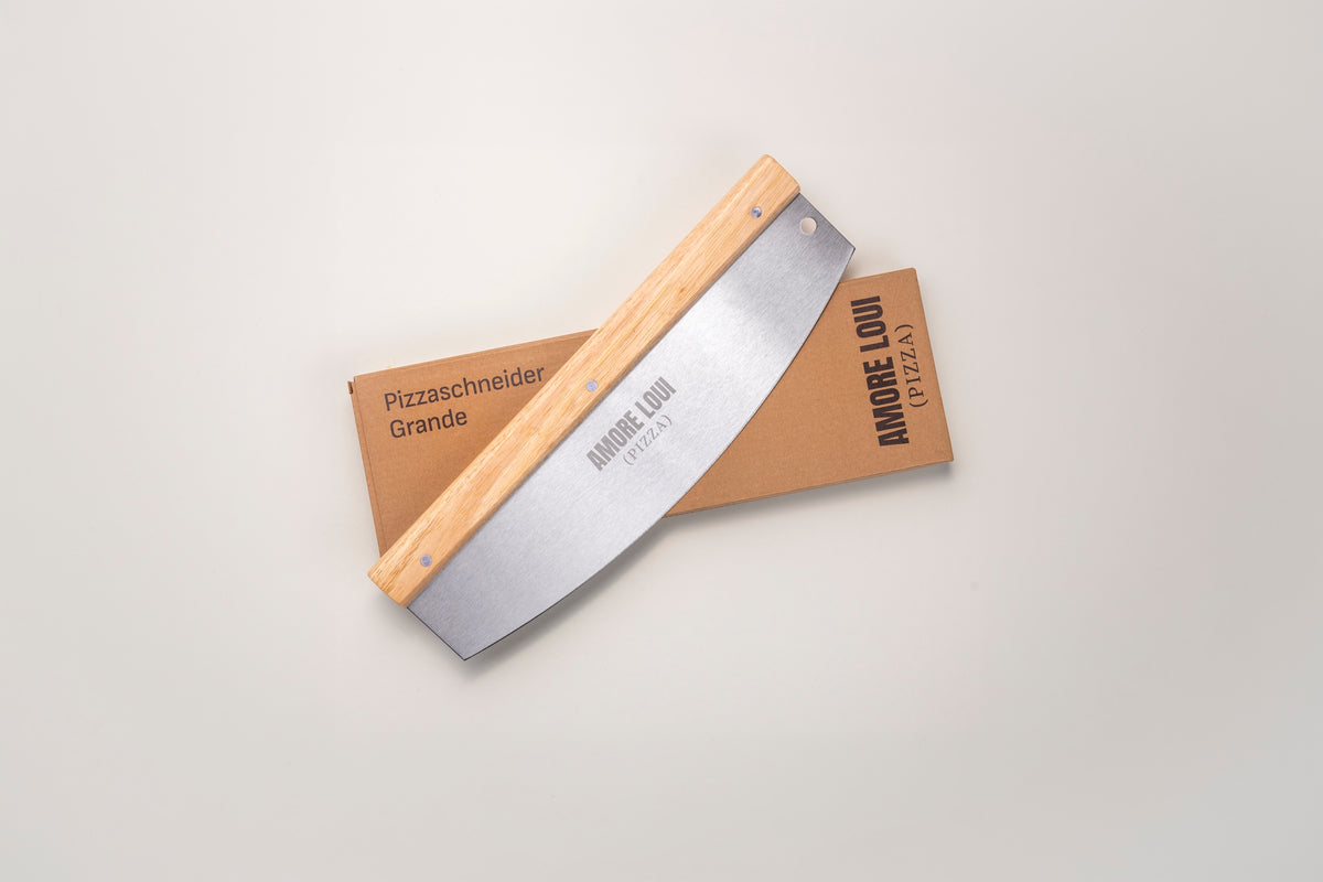 Pizzaschneider Grande mit Holzgriff neben seiner Verpackung