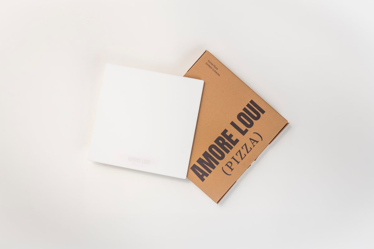 Weißer Pizzastein neben seiner AMORE LOUI Verpackung