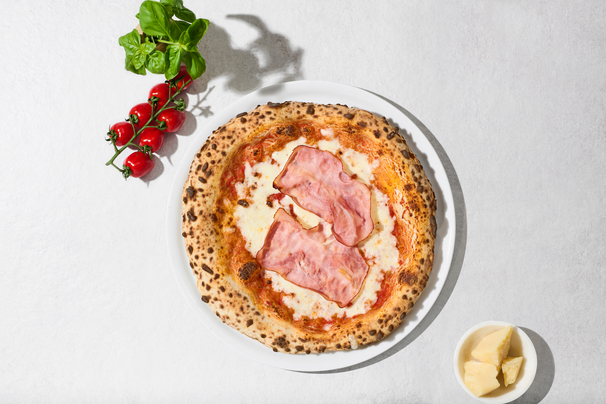 Pizza Cotta mit Zutaten daneben, von oben
