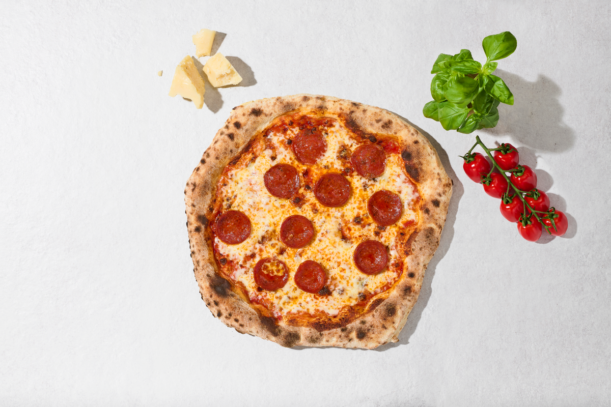 Pizza Diavola mit Zutaten daneben, von oben