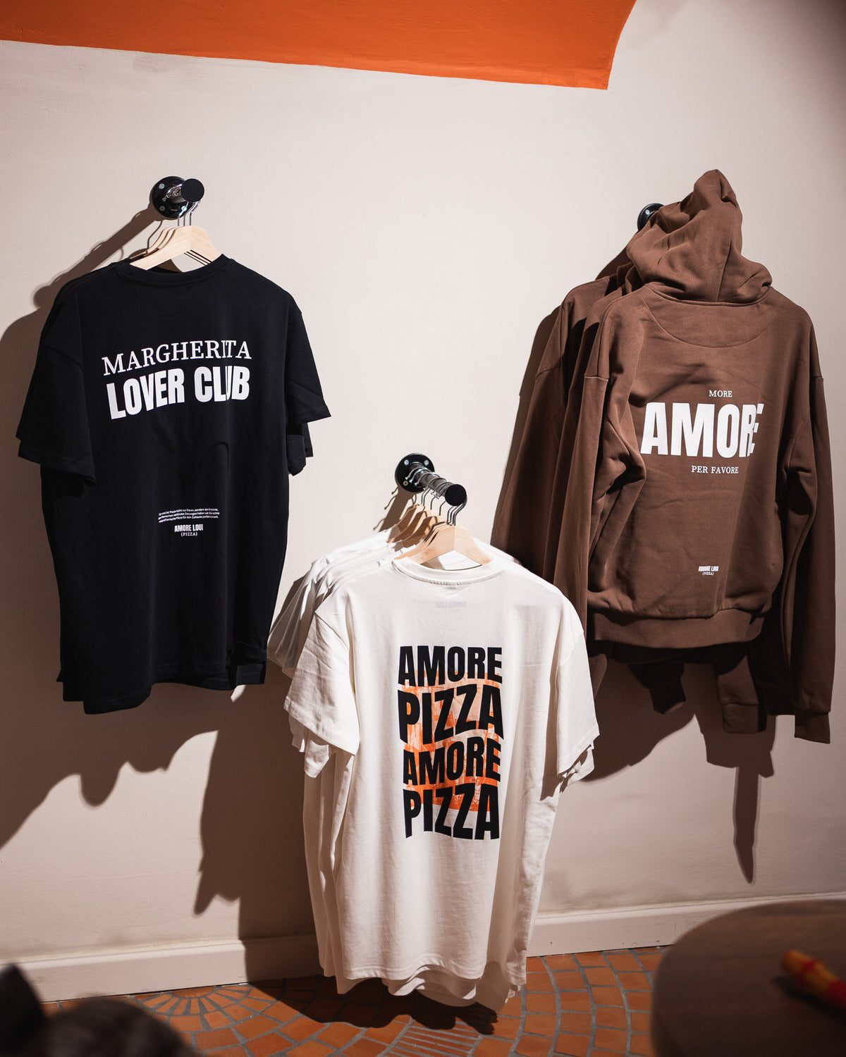 AMORE LOUI Shirts und Hoodie auf Kleiderbügeln