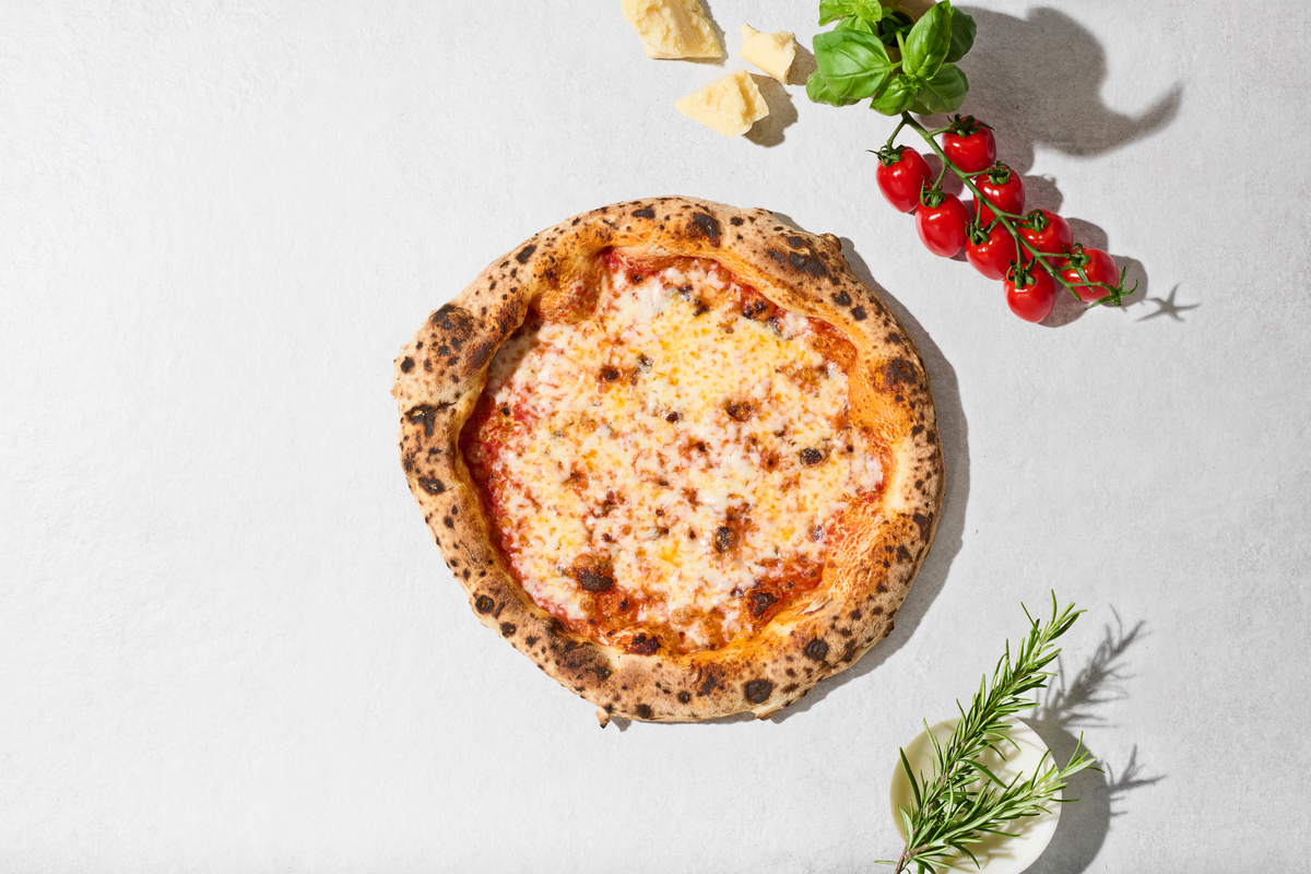 Pizza Margherita mit Zutaten daneben, von oben
