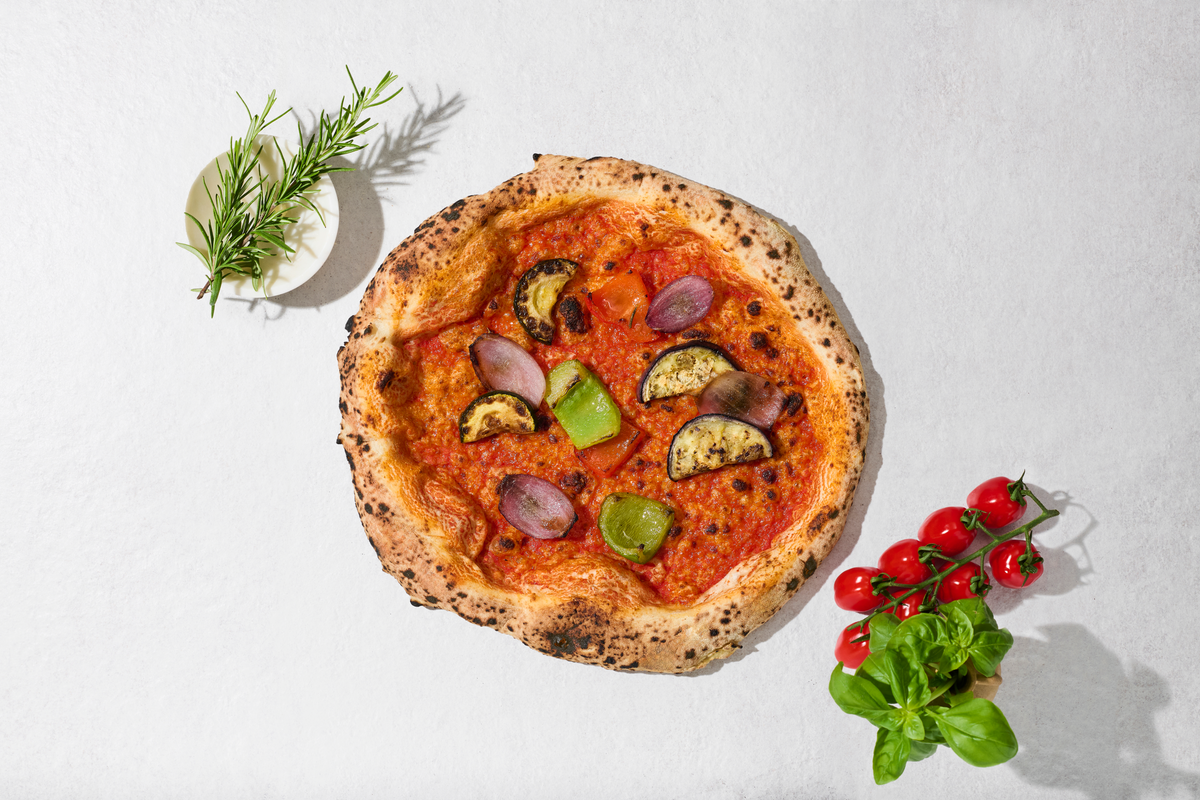 Pizza Mediterran mit Zutaten daneben, von oben