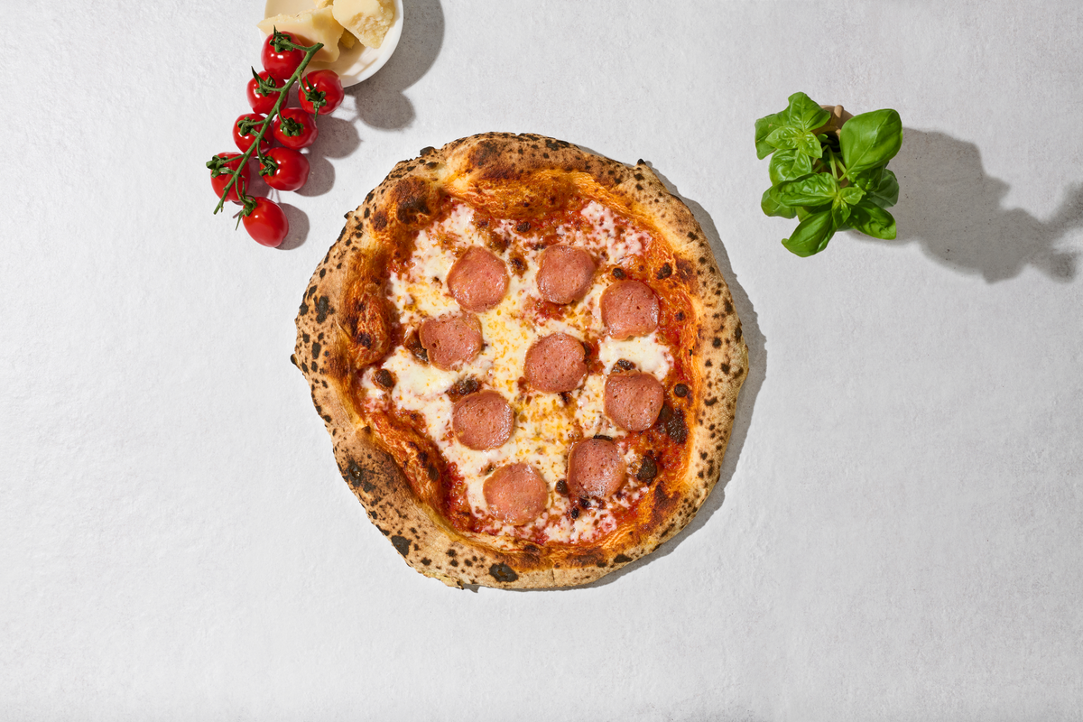 Pizza Salami mit Zutaten daneben, von oben