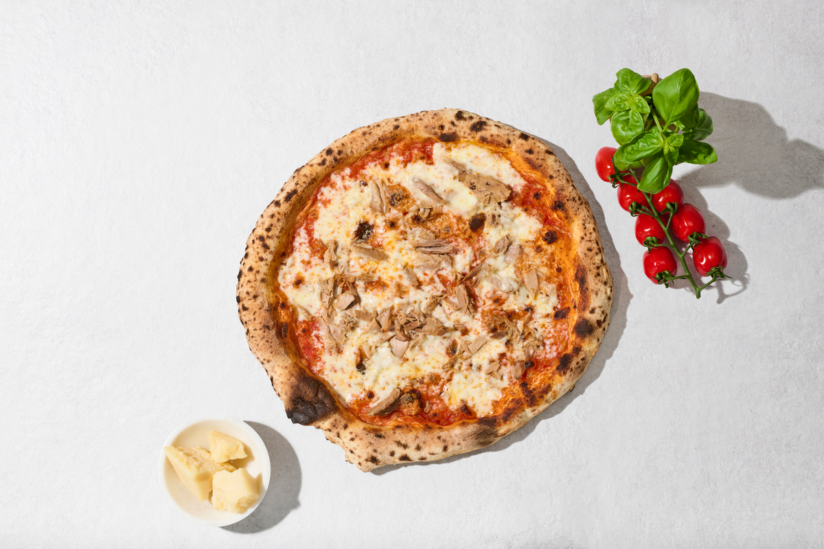 Pizza Tuna mit Zutaten daneben, von oben